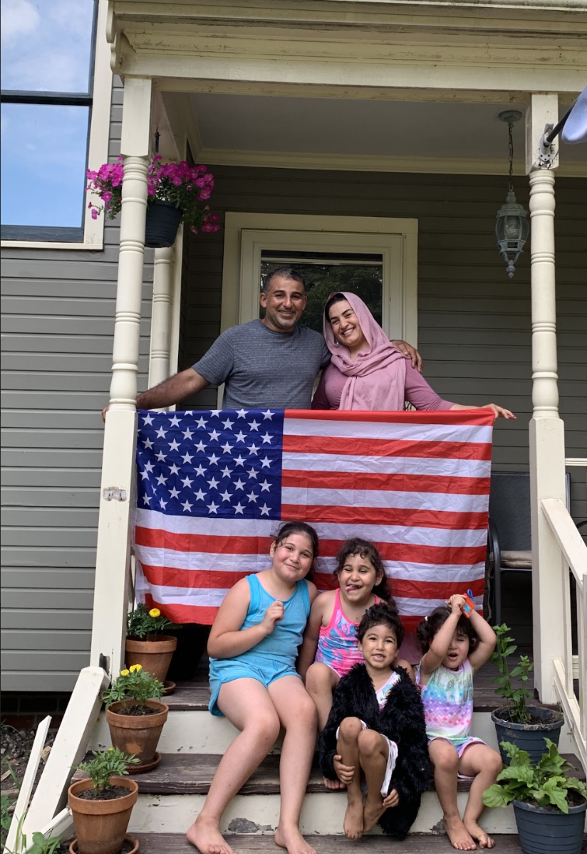Family on front porch with flag